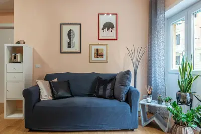 a blue couch sitting in a living room at GuestHost - Roma Trastevere Vibes Apartment in Rome
