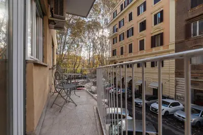 a balcony of a building with chairs and a table at GuestHost - Roma Trastevere Vibes Apartment in Rome