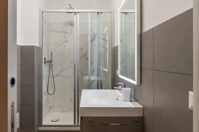 a bathroom with a shower and a white sink at GuestHost - Roma Trastevere Vibes Apartment in Rome