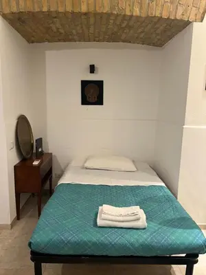 a bedroom with a bed with a green blanket and a mirror at Home Rent Mancini in Rome