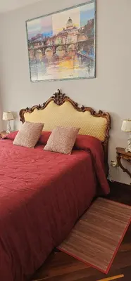 a bedroom with a bed with a red comforter at Stanza classica Eur Tintoretto in Rome
