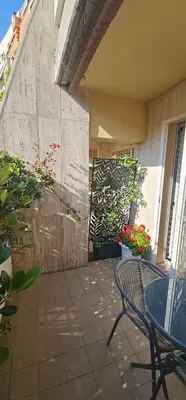 a patio with a table and chairs and flowers at Stanza classica Eur Tintoretto in Rome