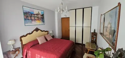 a bedroom with a red bed and a chandelier at Stanza classica Eur Tintoretto in Rome