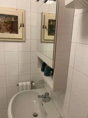 a white bathroom with a sink and a mirror at Allegra’s House Barberini in Rome