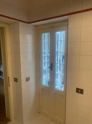 a bathroom with a door and windows in a room at Allegra’s House Barberini in Rome