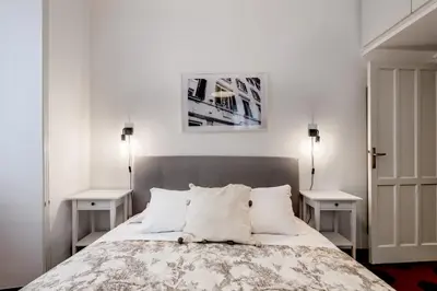 a bedroom with a bed with two night stands and two tables at Piazza Testaccio Home apt E1- Luminoso con vista piazza Testaccio in Rome