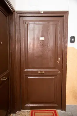 a wooden door in a room with a rug at Piazza Testaccio Home apt E1- Luminoso con vista piazza Testaccio in Rome
