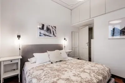 a white bedroom with a large bed with white walls at Piazza Testaccio Home apt E1- Luminoso con vista piazza Testaccio in Rome