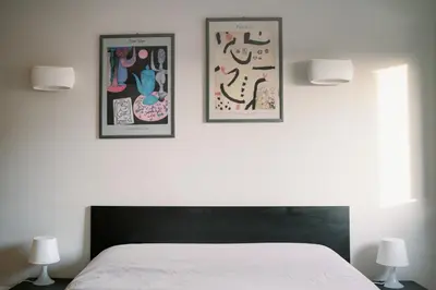 a bedroom with two pictures on the wall and a bed at Romantic apartment [Metro A Ponte Lungo] in Rome