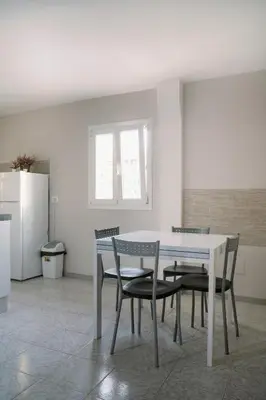 a dining room with a white table and chairs at Romantic apartment [Metro A Ponte Lungo] in Rome