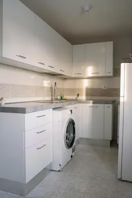 a kitchen with white cabinets and a washing machine at Romantic apartment [Metro A Ponte Lungo] in Rome