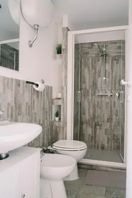 a bathroom with a shower and a toilet and a sink at Romantic apartment [Metro A Ponte Lungo] in Rome