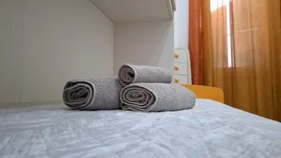 a pile of towels sitting on top of a bed at FaMaCrì Home in Rome