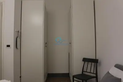 a room with a chair and a door with a sign at Casa di Pera in Rome