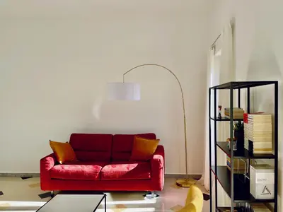 a red couch in a living room with a lamp at GuestHost - The Design Pasta Apartment in Rome