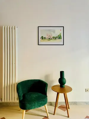 a green chair and a table in a room at GuestHost - The Design Pasta Apartment in Rome