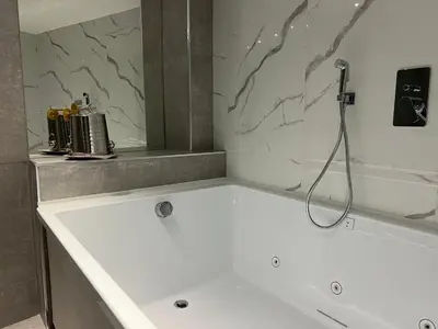 a white bath tub with a shower in a bathroom at LEMON SUITES APARTMENTS in Rome