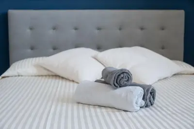 a bed with two towels and two pillows on it at LEMON SUITES APARTMENTS in Rome