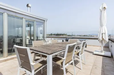 a dining table and chairs on a balcony with a view at Trastevere Attic Raffaello’s rooms in Rome