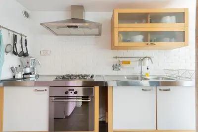 a kitchen with a stove and a sink at Trastevere Attic Raffaello’s rooms in Rome