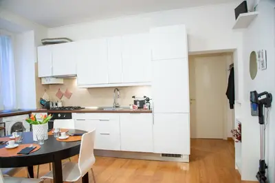 a kitchen with white cabinets and a table with chairs at Piazza Testaccio Home appartamento E 2 Accogliente e Silenzioso in Rome