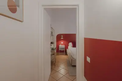 a living room with a couch and a red wall at Boho Chic Apartment By Nosdom Properties in Rome