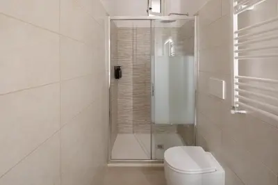 a white bathroom with a shower and a toilet at Boho Chic Apartment By Nosdom Properties in Rome