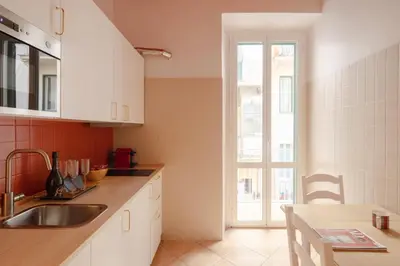 a kitchen with white cabinets and a sink and a window at Boho Chic Apartment By Nosdom Properties in Rome