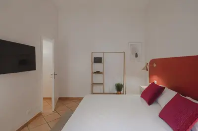 a bedroom with a large white bed with two red pillows at Boho Chic Apartment By Nosdom Properties in Rome