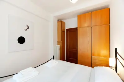 a bedroom with a bed and a wooden cabinet at CAVALLEGGERI HOUSE in Rome