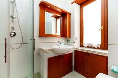 a bathroom with a sink and a glass shower at CAVALLEGGERI HOUSE in Rome