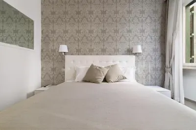a bedroom with a large white bed with two lamps at Le Suite dei Mercanti in Rome