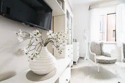 a white vase with flowers on a table in a room at Le Suite dei Mercanti in Rome