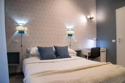 a bedroom with a bed and two lights on the wall at Arezzo 38 in Rome
