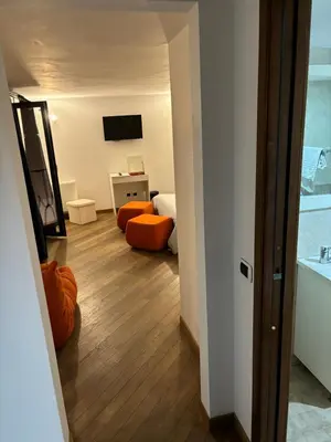 a room with a bedroom with orange chairs and a mirror at Boutique rooms trastevere in Rome