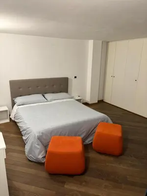a bedroom with a large bed with two orange seats at Boutique rooms trastevere in Rome
