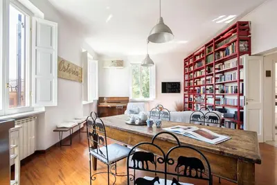 a dining room with a large wooden table and chairs at Vittoria in Trastevere Apartment in Rome