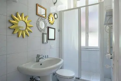 a bathroom with a sink and a toilet and a mirror at Vittoria in Trastevere Apartment in Rome