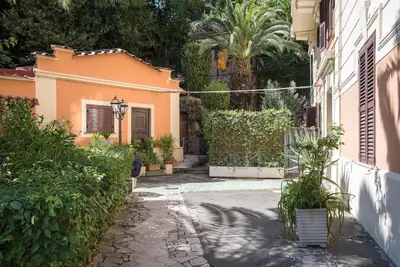 an alley with a house and some bushes and trees at Vittoria in Trastevere Apartment in Rome