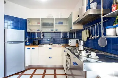 a kitchen with blue tiles and a white refrigerator at Vittoria in Trastevere Apartment in Rome