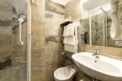 a bathroom with a sink and a toilet and a mirror at Vaticana Ottaviani Roma in Rome