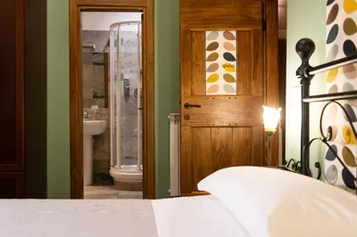 a bedroom with a bed and a bathroom with a shower at Vaticana Ottaviani Roma in Rome