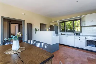 a kitchen with white cabinets and a wooden table at iFlat Magical flat by the Tiber in Rome