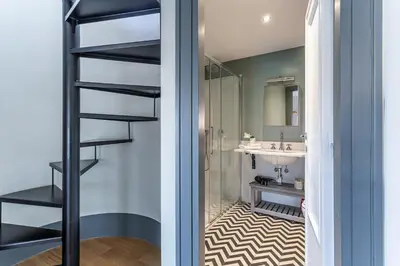 a bathroom with a black staircase and a sink at iFlat Magical flat by the Tiber in Rome