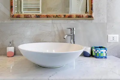 a white bowl sink in a bathroom with a mirror at Cornelia - Charme Apartment in Rome