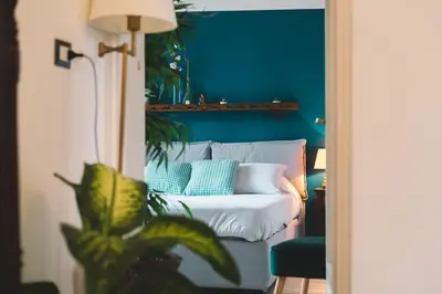 a blue room with a couch and a blue wall at Vaticano/Trastevere Floreal Suite in Rome