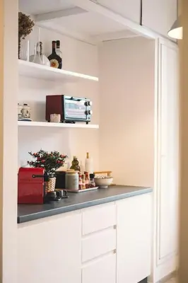 a kitchen with white cabinets and a counter at Vaticano/Trastevere Floreal Suite in Rome