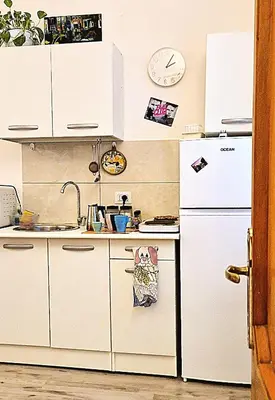 a kitchen with white cabinets and a white refrigerator at MusicArt House in Rome