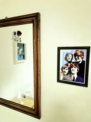 a mirror on a wall with a picture of a group of people at MusicArt House in Rome