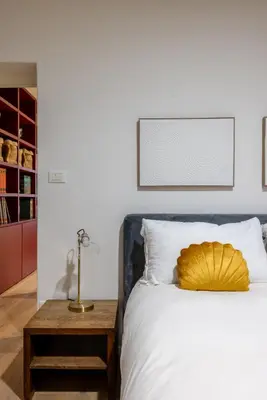 a bedroom with a bed with a yellow pillow on it at Urban Chic 2 BR Vatican Escape in Rome
